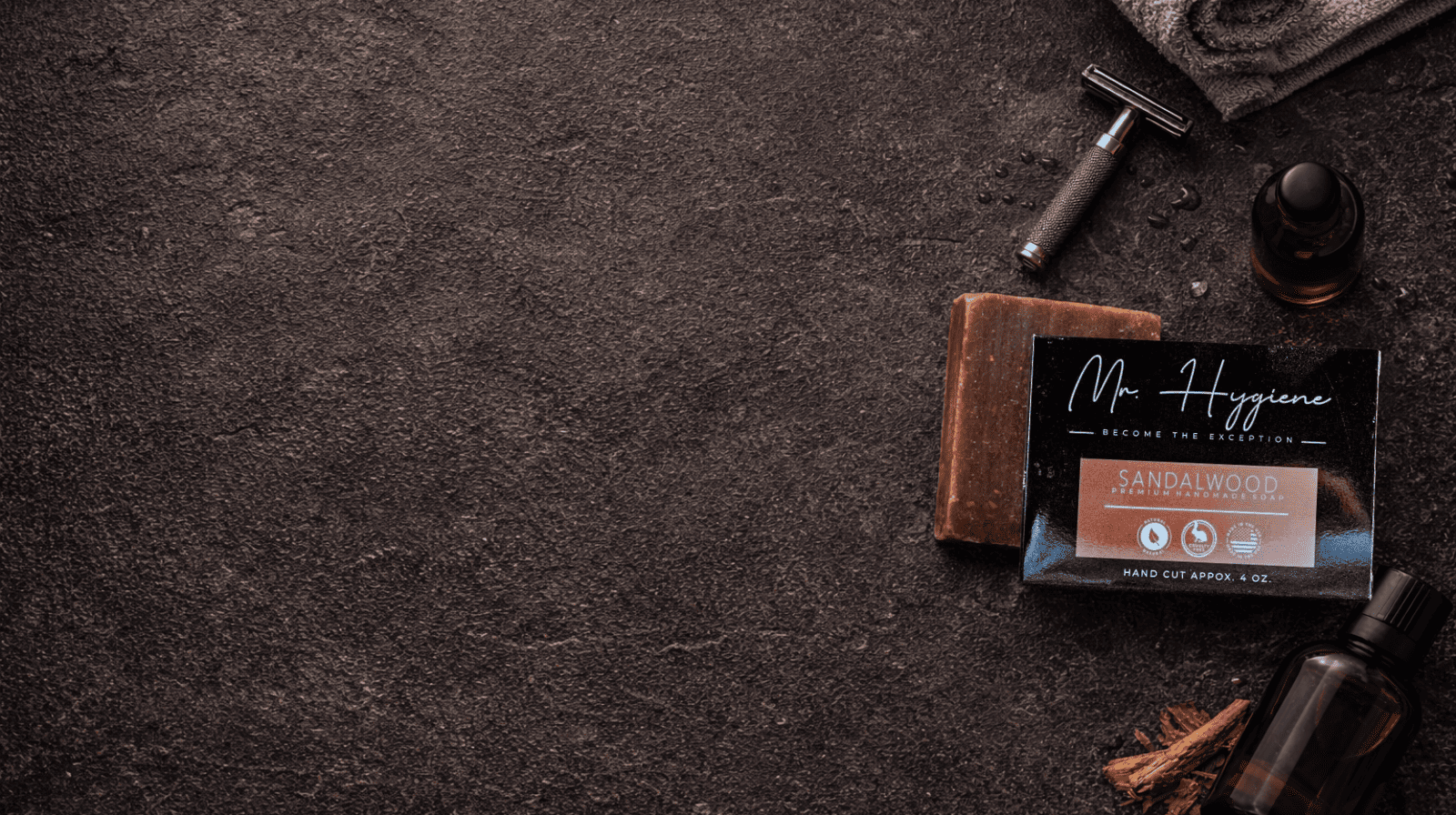Shaving products including a bar of soap, a razor, and a towel on a dark surface.
