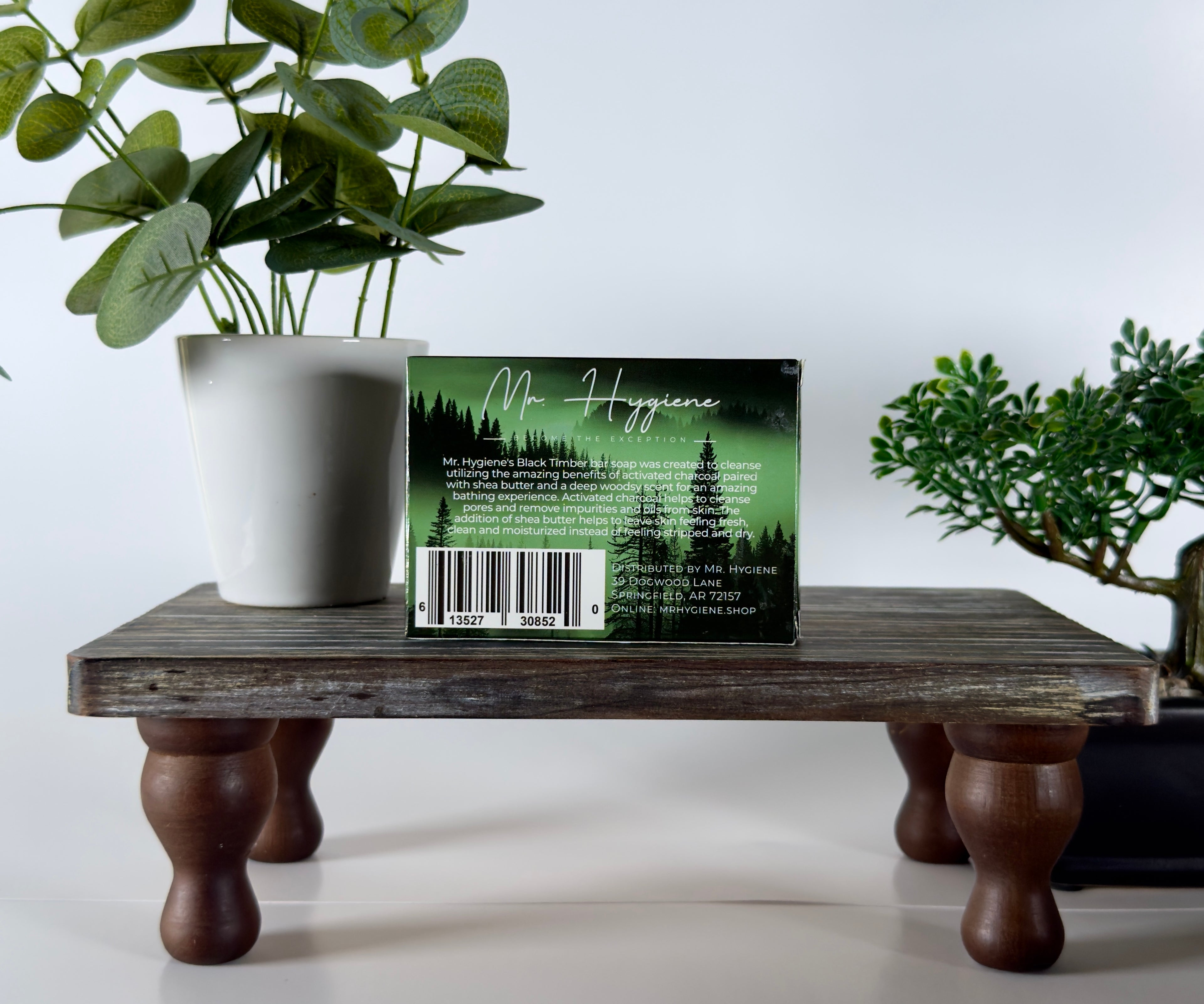 Product packaging with a barcode on a wooden stand with plants in the background