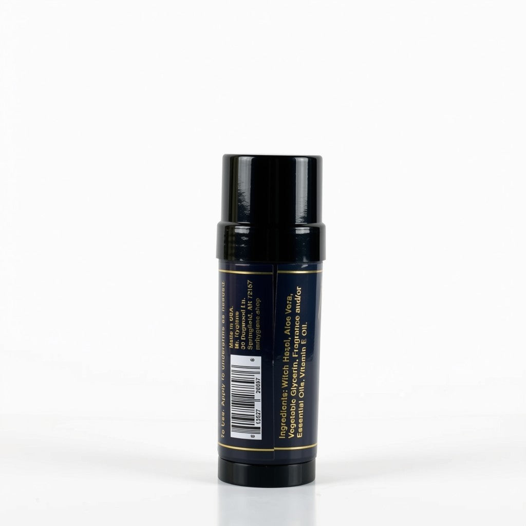 A single cosmetic stick container, shown from the back, featuring a glossy black cap and a dark navy blue body with gold text and a barcode label.