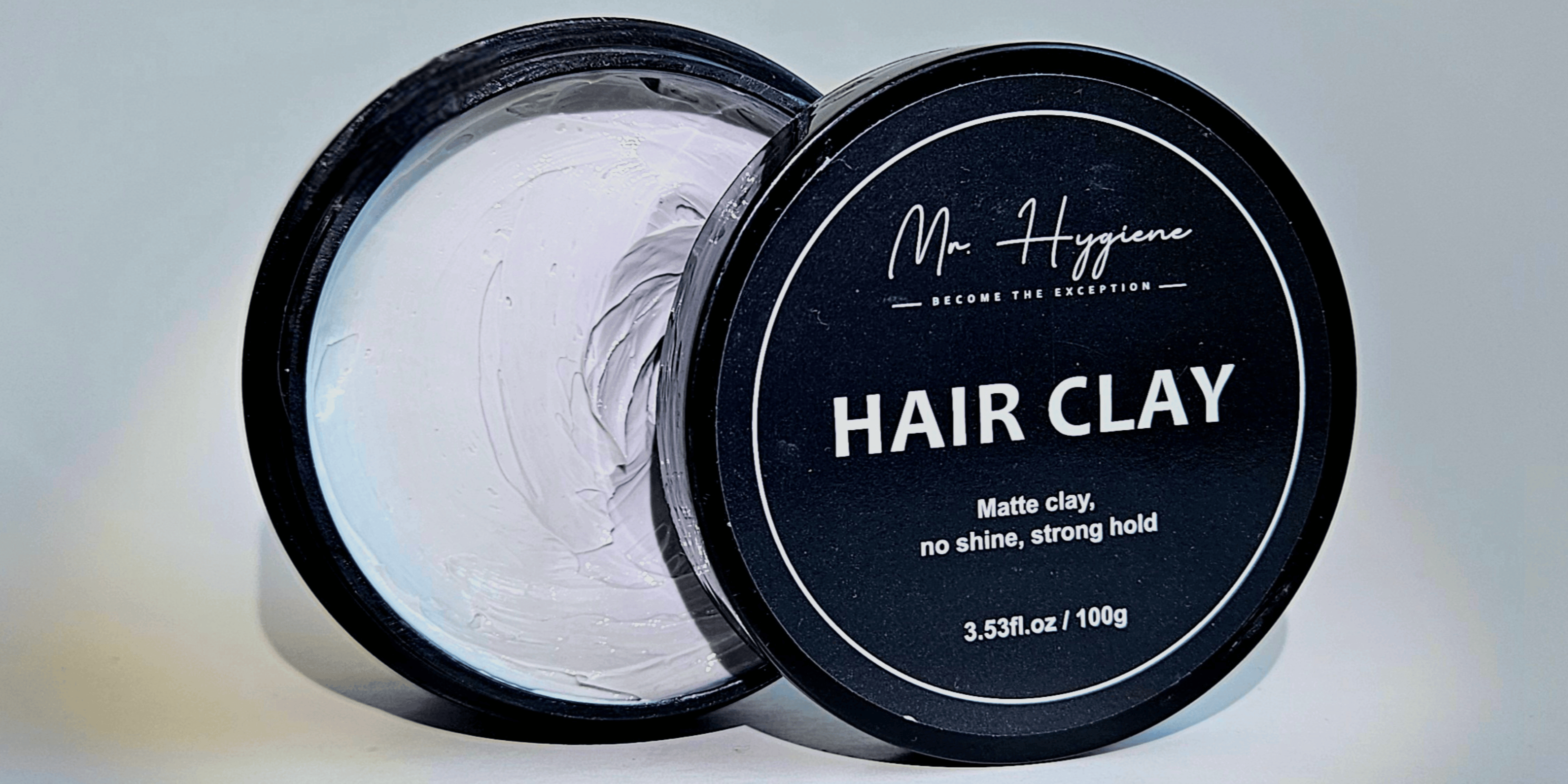 Hair clay jar with open lid on a light gray background