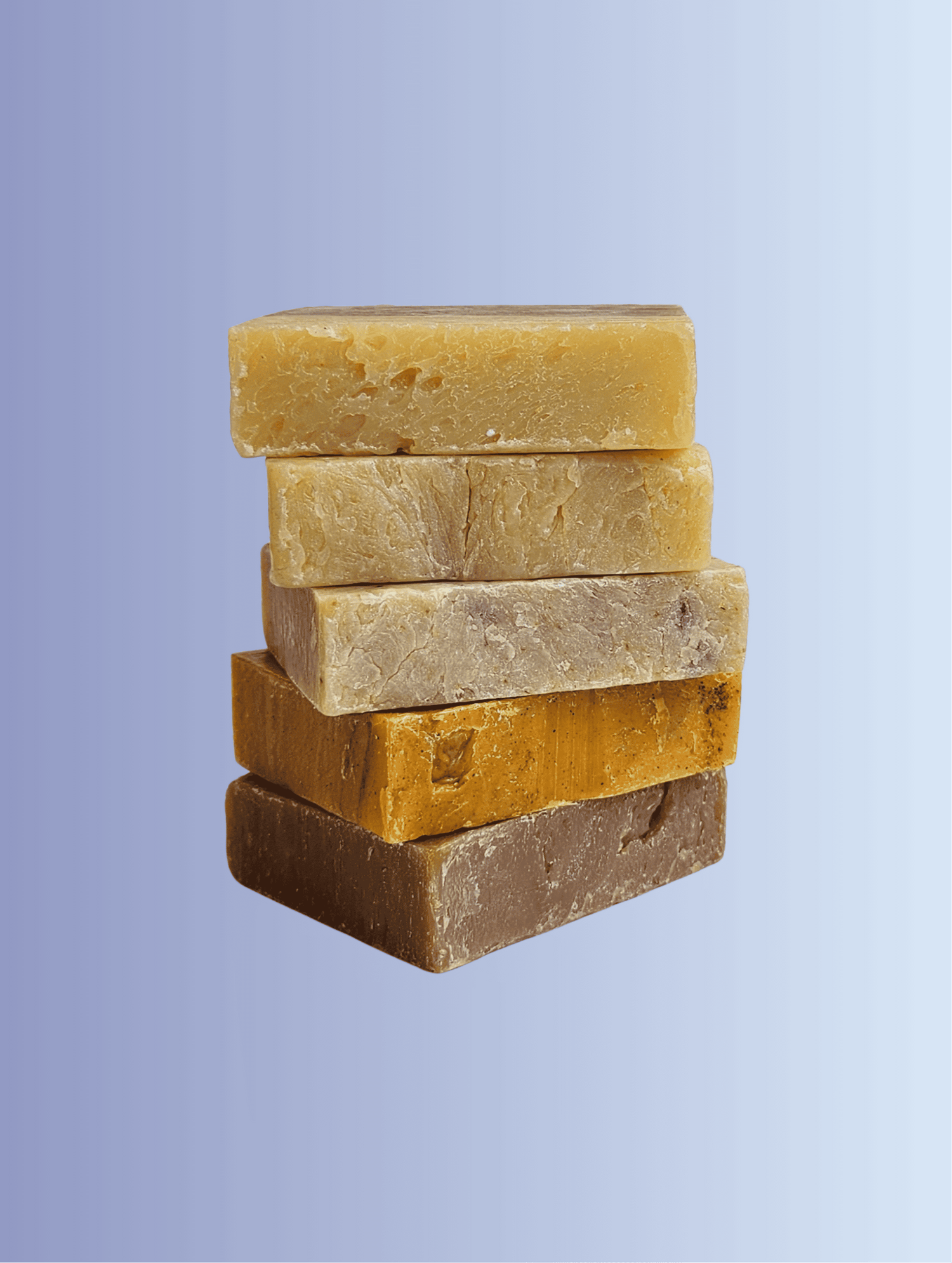 Stack of five different colored soap bars on a light purple background